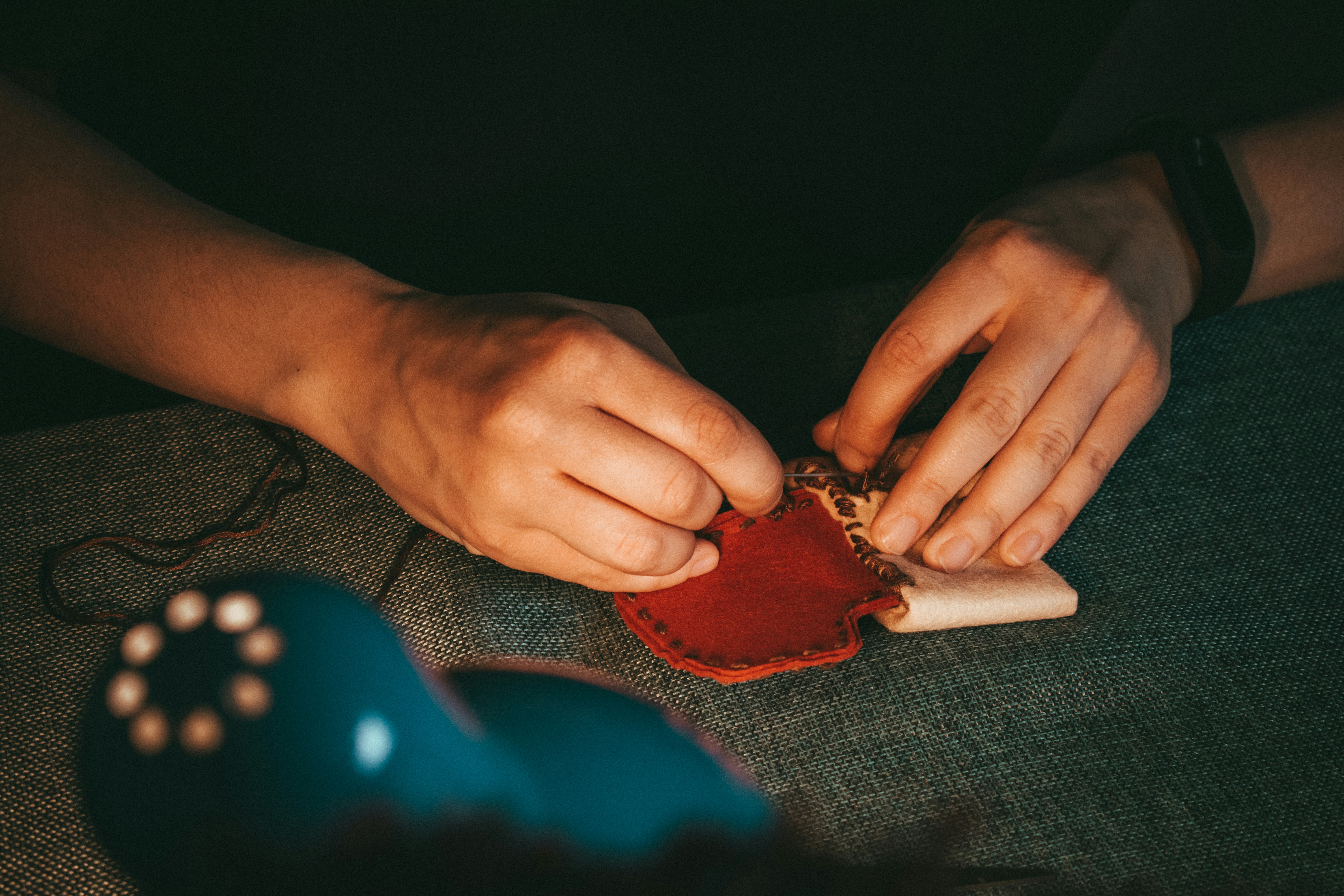 Weathered hands working carefully at a wooden table in warm afternoon light